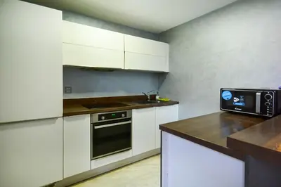a kitchen with white cabinets and a black oven at Luxueux Duplex 2CH dans une magnifique résidence in Marrakech
