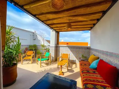 a living room with a couch and chairs on a patio at Dar Amane - Charmante maison marocaine in Marrakech