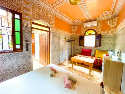 a bedroom with a bed and a couch in a room at Dar Amane - Charmante maison marocaine in Marrakech