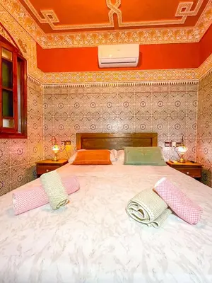 a bedroom with a large bed with two pillows on it at Dar Amane - Charmante maison marocaine in Marrakech