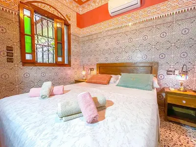 a bedroom with a large bed with two chairs at Dar Amane - Charmante maison marocaine in Marrakech