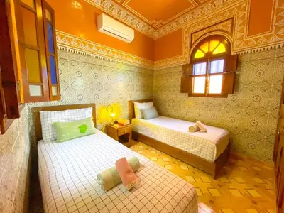 a bedroom with two beds and a window at Dar Amane - Charmante maison marocaine in Marrakech