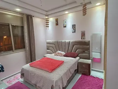 a bedroom with a bed with red pillows on it at Chez bousfyha in Marrakech