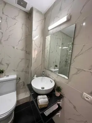 a bathroom with a sink and a toilet and a mirror at Charmant appartement avec piscine 2chambres au cœur de Guéliz in Marrakech