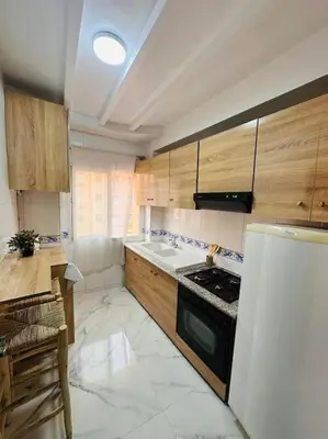 a kitchen with a stove and a white refrigerator at Charmant appartement avec piscine 2chambres au cœur de Guéliz in Marrakech