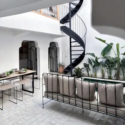a room with chairs and a table and a staircase at Riad de l'Ô with Pool, Rooftop, Free Breakfast in Marrakech