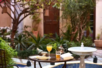 a table with two glasses of orange juice on it at Riad L'Aziza in Marrakech