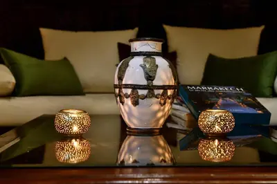 a glass vase sitting on a table with candles on it at Riad L'Aziza in Marrakech