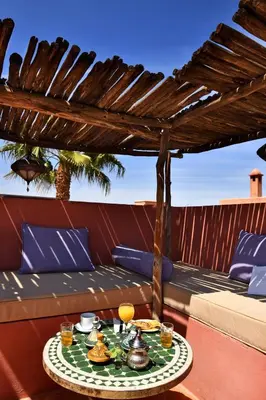 a table with food on a patio with a pergola at Riad L'Aziza in Marrakech