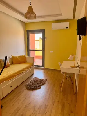 a living room with a couch and a table at Jardin Yves Appartement 2 Chambres Chic in Marrakech