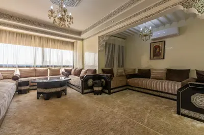 a large living room with couches and a chandelier at Appartement Raffiné au Centre in Marrakech