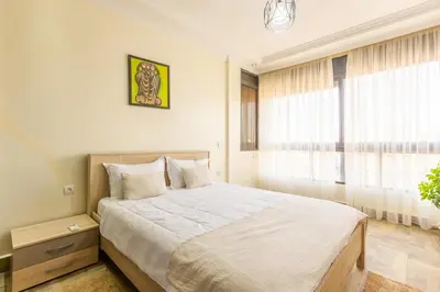 a bedroom with a large bed and a window at Appartement Raffiné au Centre in Marrakech