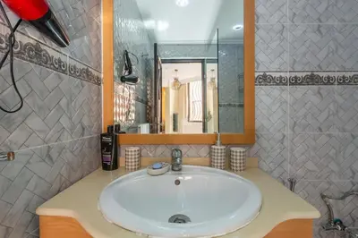 a bathroom with a white sink and a mirror at Appartement Unique au Centre in Marrakech