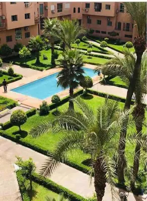 an aerial view of a resort with a pool and palm trees at Appartement Unique au Centre in Marrakech