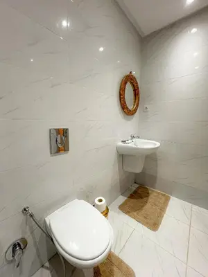 a white bathroom with a toilet and a sink at Condo in marrakech with pool in Marrakech