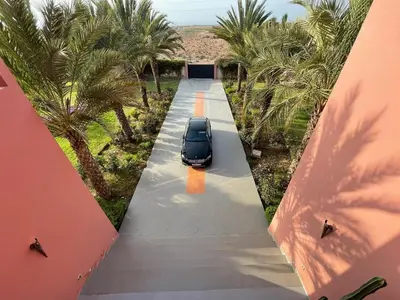 a car parked on a driveway with palm trees at Villa Dar El Hna in Marrakech