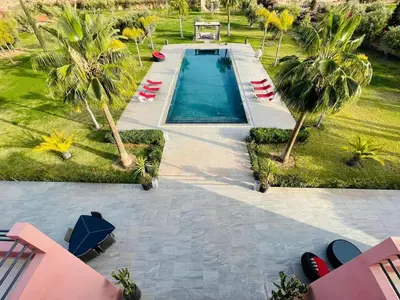 an overhead view of a swimming pool with palm trees at Villa Dar El Hna in Marrakech