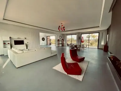 a living room with a white couch and red chairs at Villa Dar El Hna in Marrakech