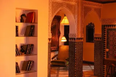 a living room with a chair and a room with books at LUXURY apartment in Marrakech