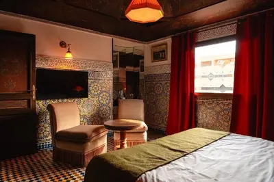 a bedroom with a bed and a chair and a window at LUXURY apartment in Marrakech