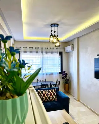 a living room with a blue couch and a table at Cozy apartment in city center in Marrakech