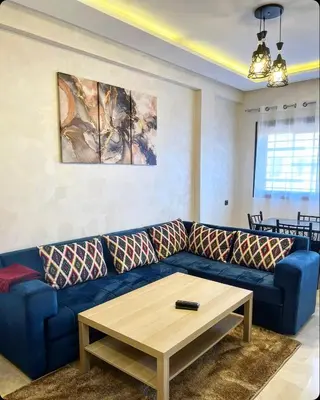 a blue couch in a living room with a table at Cozy apartment in city center in Marrakech
