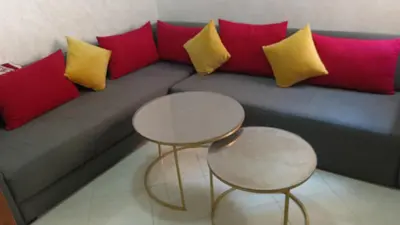 a couch with red and yellow pillows and two tables at Marrakech Chic and moderne appartement in Marrakech