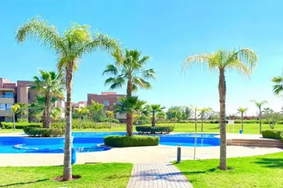 a resort with a swimming pool and palm trees at Prestigia Golf entrée Agate (wifi) in Marrakech