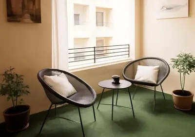 two chairs and a table in a room with a window at Appart vacance safaa in Marrakech