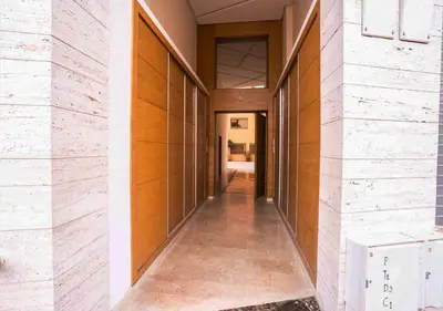 a hallway of a building with wood and stone walls at Appart vacance safaa in Marrakech