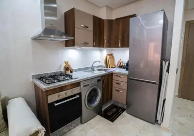 a kitchen with a refrigerator and a washing machine at Appart vacance safaa in Marrakech