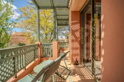a balcony with a table and chairs on it at Family Stay aux jardins de la palmeraie in Marrakech