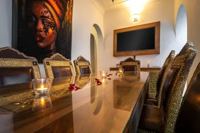 a conference room with a table and chairs and a television at Riad Dekkak, Maison complète en exclusivité in Marrakech