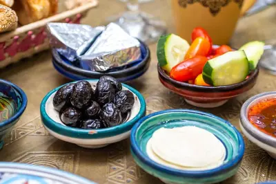 a table topped with bowls of food with vegetables and dip at Riad Dekkak, Maison complète en exclusivité in Marrakech