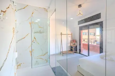 a glass shower in a bedroom with a bed at modern friendly appt in gueliz in Marrakech