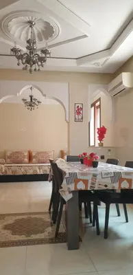 a dining room with a table and a couch at Mabrouka in Marrakech