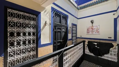 a house with black doors and blue and white walls at Riad Mamma MARRAKESH in Marrakech