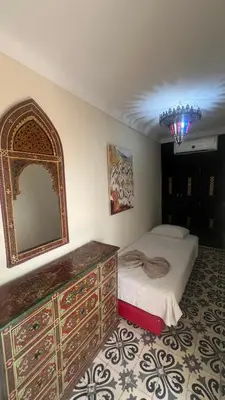 a bedroom with a bed and a dresser with a mirror at Riad Mamma MARRAKESH in Marrakech