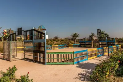 a tennis court with blue and yellow fencing at Appartement avec Solarium Privé au Vizir Résidence Prestigieuse avec Accès au Parc in Marrakech
