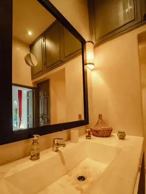 a bathroom with a sink and a large mirror at Riad La Smala in Marrakech