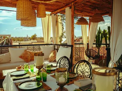 a patio with a couch and a table and chairs at Riad La Smala in Marrakech