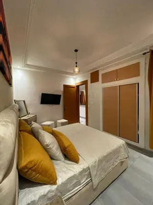 a bedroom with a large bed with yellow pillows at Appartements Guéliz Zerktouni in Marrakech