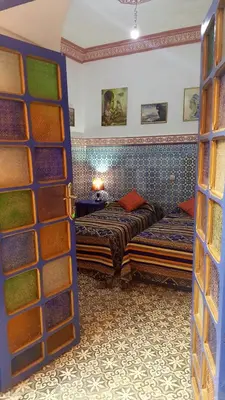 a room with two beds and a door open at Riad dar kader C in Marrakech