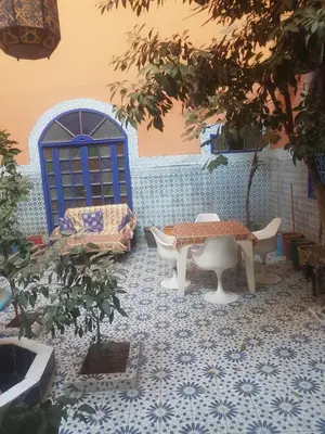 a patio with a table and chairs on a tile floor at Riad dar kader C in Marrakech