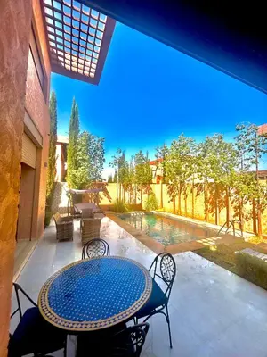 a patio with a table and chairs and a pool at Villa djelloul s in Marrakech