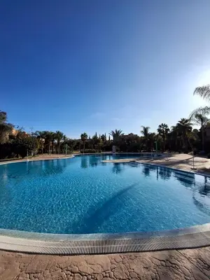 a large swimming pool with blue water at Havre de paix bohème avec rooftop privée in Marrakech