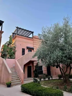 a building with stairs and a tree in front of it at Havre de paix bohème avec rooftop privée in Marrakech