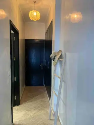 a room with a ladder and a black door at Havre de paix bohème avec rooftop privée in Marrakech