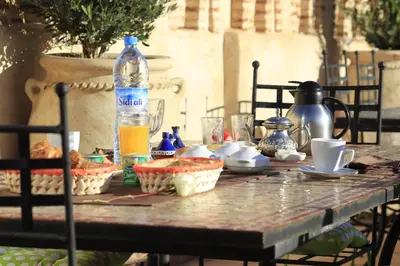 a table with food and a bottle of water on it at Riad Fleur d'Orient in Marrakech