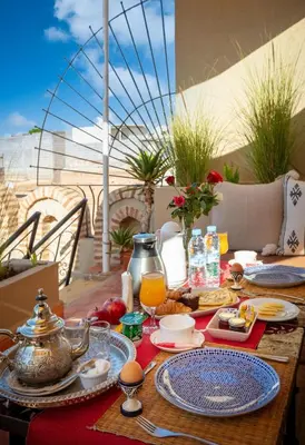 a table with breakfast food on a balcony with a view at Riad Fleur d'Orient in Marrakech